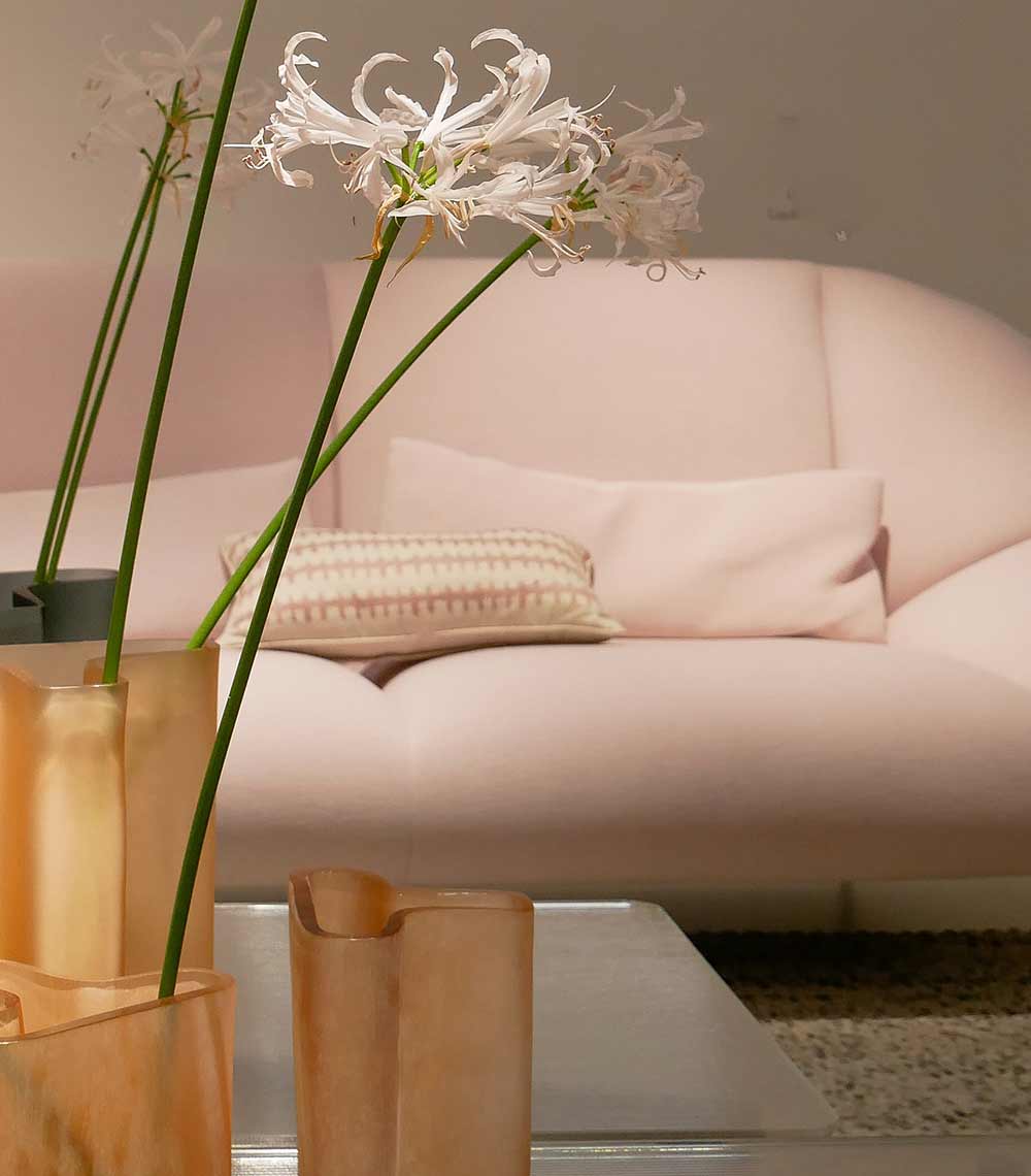 A couch and vase with flowers on the table