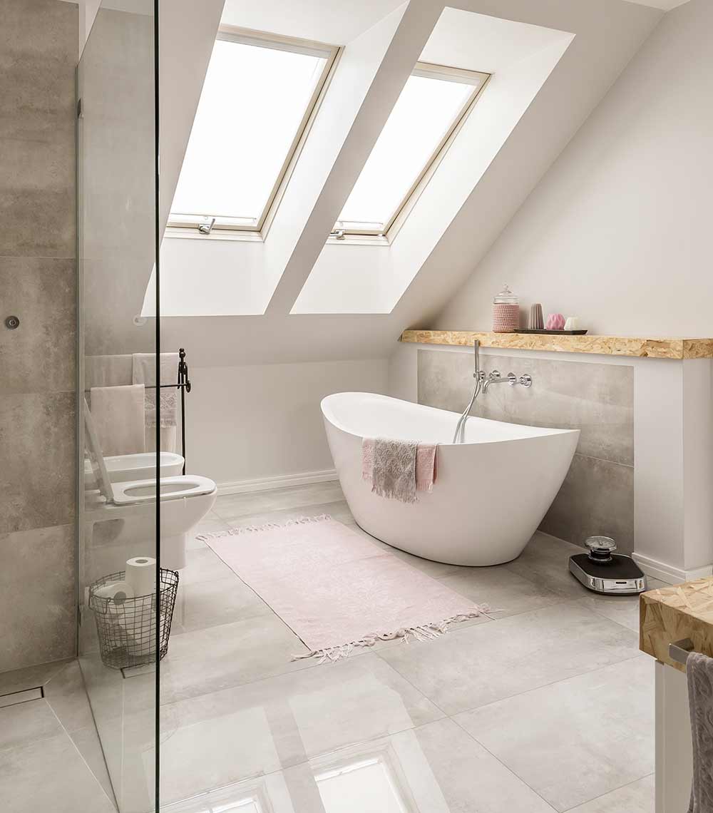 A bathroom with a large white tub and toilet.