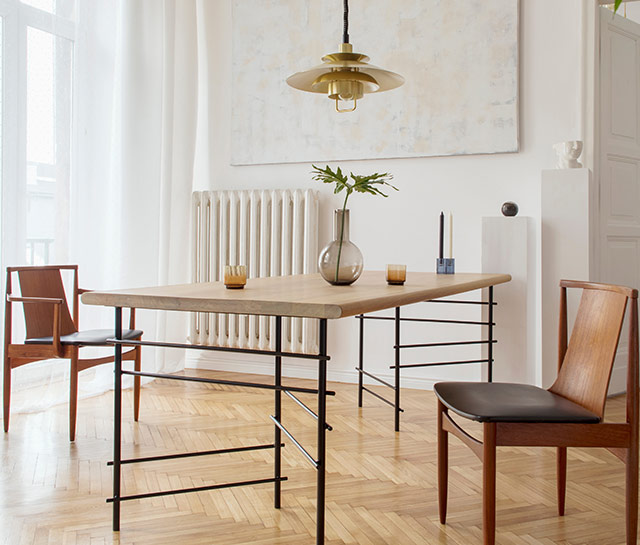 A dining room table with two chairs and a lamp