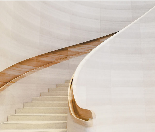 A staircase with a curved wooden handrail.