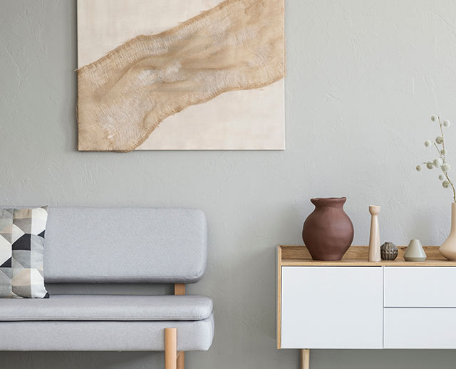 A living room with a couch and a painting on the wall