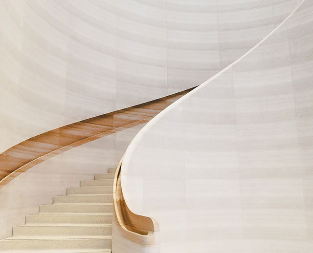 A white staircase with wooden handrails and steps.