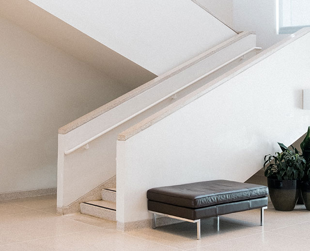 A black bench sitting in front of stairs.