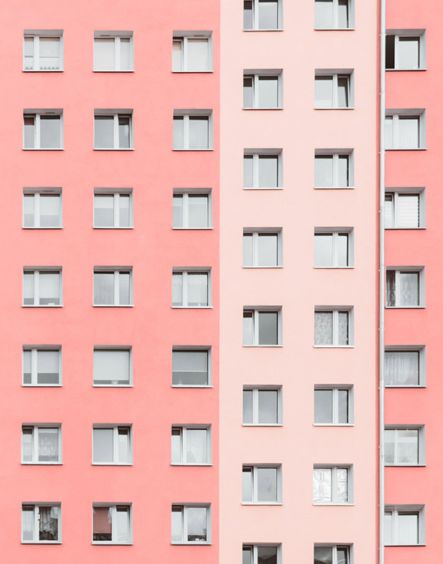 A pink building with two windows on the side.