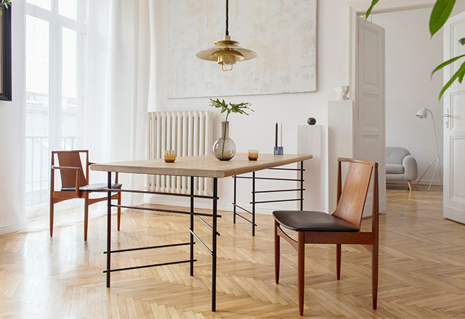 A dining room table with four chairs and a lamp.