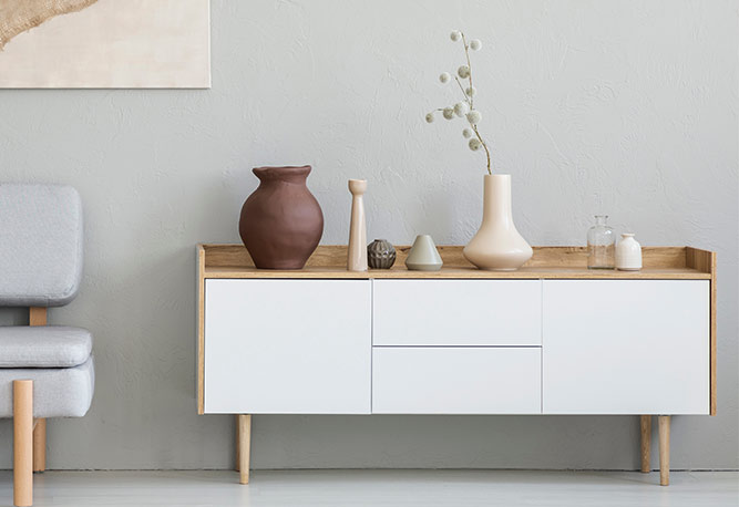 A white cabinet with some vases on top of it