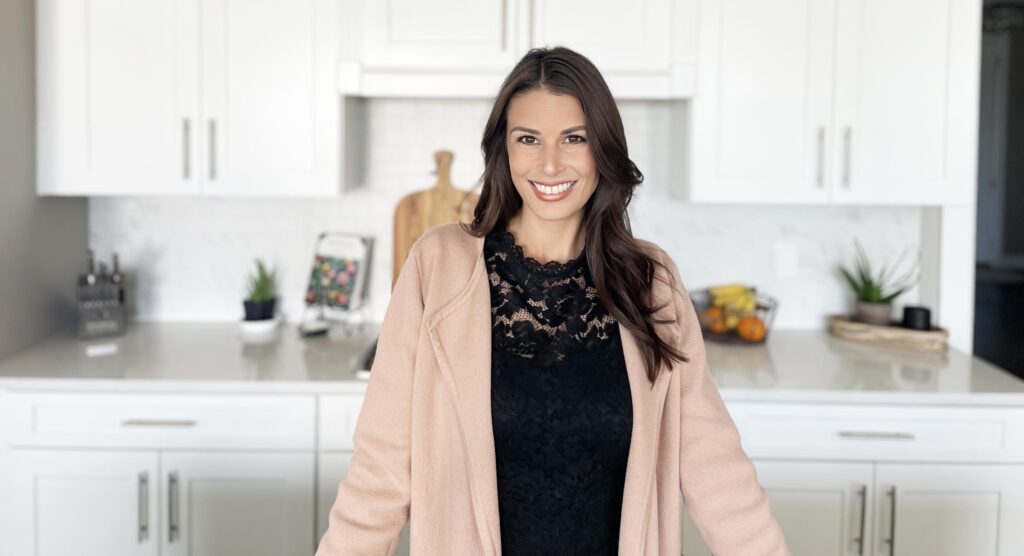 A woman standing in front of a kitchen counter.